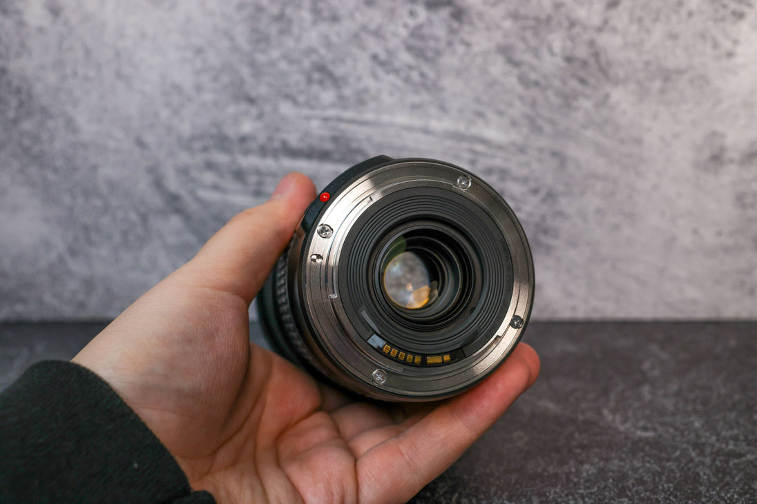 Rear element view of a Canon 24-105mm lens being held by a hand