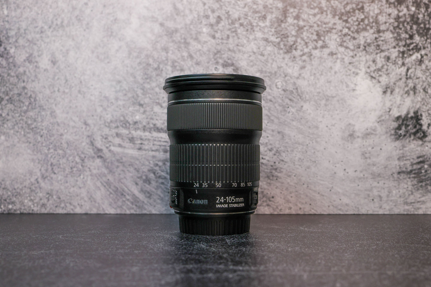 A Canon 24-105mm lens sitting vertically on the rear lens cap