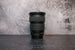 A side angle of the Canon 24-105 lens sitting vertically on the rear lens cap