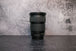 A side angle of the Canon 24-105 lens sitting vertically on the rear lens cap