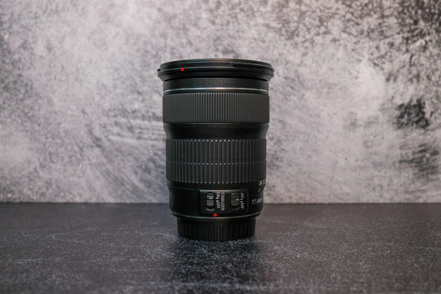 The opposite side angle of a Canon 24-105mm lens sitting vertically on the rear lens cap