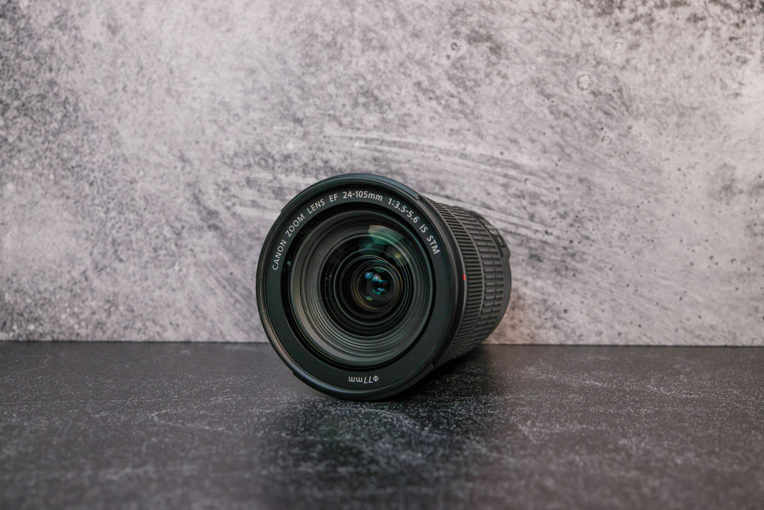A slightly angled lens view of the Canon 24-105mm lens laying flat on a surface