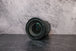 A slightly angled lens view of the Canon 24-105mm lens laying flat on a surface